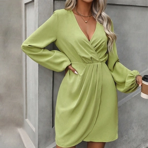 Detail of the wrap V-neckline and irregular hem on a lime green long sleeve mini dress