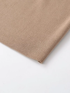 Detailed close-up of camel ribbed knit fabric texture on sleeve cuff and hemline