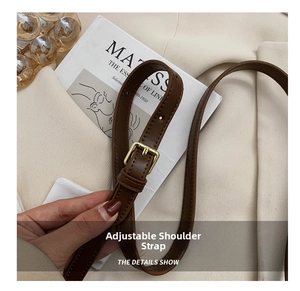 Detail of adjustable brown leather strap with premium gold metal buckle for a handbag