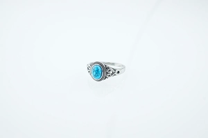 Macro detail of bohemian turquoise ring with celtic patterns and silver textured finish