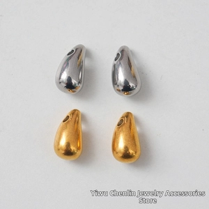 Macro detail of tear drop stainless steel jewelry pendants in gold and silver mirror finish