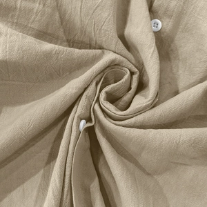 Gros plan sur la texture respirante en lin et les boutons blancs d'une chemise beige