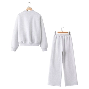 Rear view of light gray sweatshirt and wide-leg sweatpants set on a wooden hanger