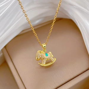 Detail of gold horse pendant necklace with white zircons and green enamel on silk