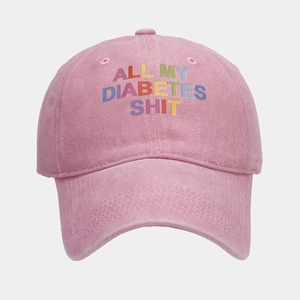 Detailed shot of pink washed denim baseball cap with colorful embroidery text