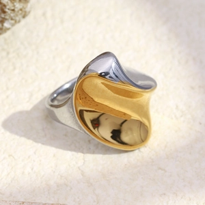 Bague torsadée plaquée or 18 carats bicolore au design moderne sur fond de pierre