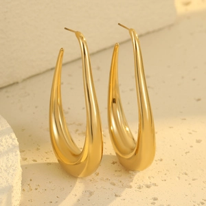 Minimalist gold U-shaped hollow teardrop earrings on white stone background