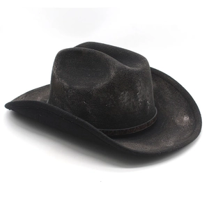 Detail of vintage black cowboy hat with distressed finish and embossed leather band