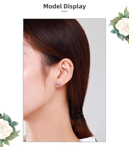 Close-up of infinity symbol silver stud earrings with cubic zirconia on a female ear