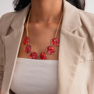 Detailed view of three-piece vintage gold necklace with textured red enamel round pendants