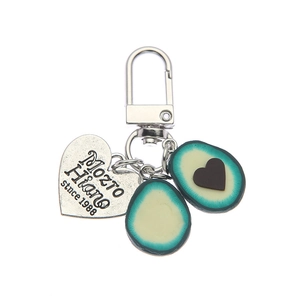 Cute avocado keychain with silver heart pendant and metal clasp on white background