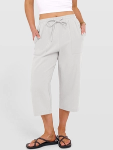 Dettaglio dei pantaloni larghi in lino grigio chiaro con coulisse e grandi tasche
