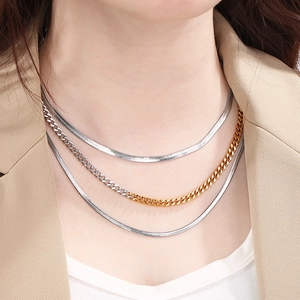 Close-up of layered stainless steel Cuban and snake chains on a model neck