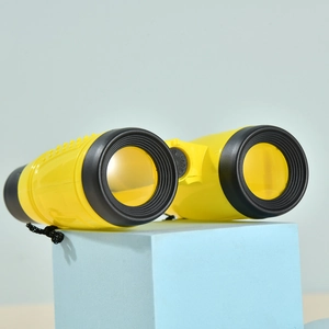 Macro shot of 6X30 yellow and black children's toy binoculars on a blue stand with neck strap