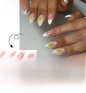 Close-up of French tip press-on nails featuring 3D sunflowers and small rhinestones