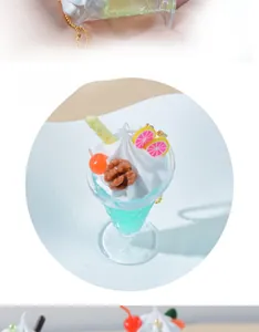 Close-up of artificial blue ice cream sundae keychain with cream and fruit decor