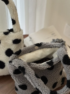 Gros plan du sac à main en peluche à pois avec fermoir magnétique et doublure douce