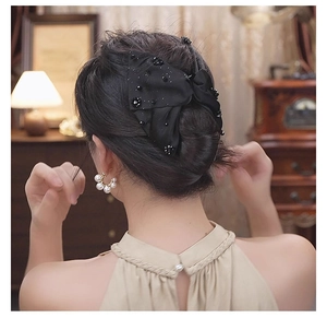 Detail of a vintage black satin double-layered bow hair clip with intricate black beads decoration
