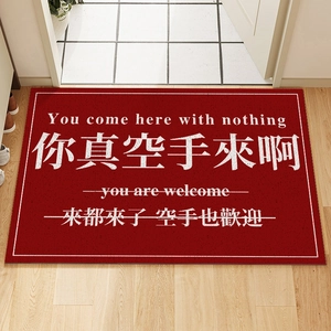 Red non-slip welcome doormat with funny text on wooden floor at entry door