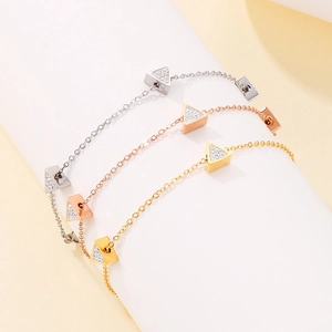 Detailed view of triangular pendants with pavé crystals on three colorful metal chains