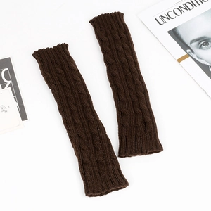 Detailed close-up of brown cable-knit arm warmers with intricate braided wool texture