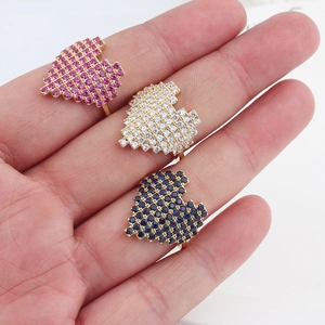 Detailed shot of gold-plated rings with micro-pave hearts in pink, white and blue colors