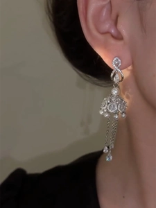 Detail of silver tassel drop earrings with pearls and crystals shown on model