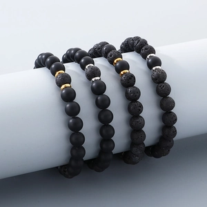 Set of four black agate and lava stone bead bracelets with gold and silver spacers