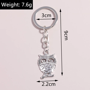Macro view of vintage silver owl keychain with detailed feather texture and dimension specs