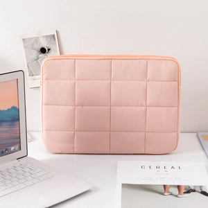 Macro view of pink quilted fabric texture on a minimalist 14-inch laptop sleeve bag