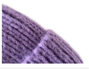 Detailed macro view of purple chunky knit fabric showing soft texture and cozy yarn fibers