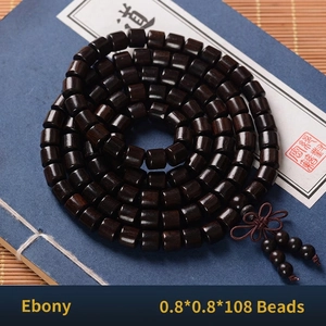 Macro detail of 108 ebony wood beads 0.8cm with traditional Chinese knot on blue book