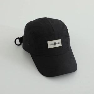 Detail of black quick-dry camper hat with CHANGE text label and metal side eyelets