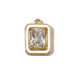 Macro detail of gold geometric pendant with white enamel and emerald-cut clear stone