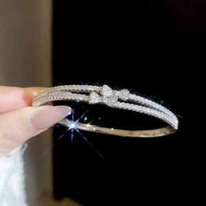 Detailed side view of silver-plated double-layer bracelet with bow and pavé zircons
