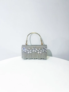 Detail of silver evening clutch with crystal flowers, rhinestones and fringe tassels