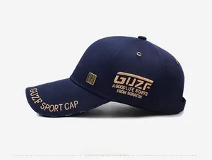 Gros plan sur la casquette bleu marine avec broderies dorées et plaque métallique de marque