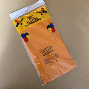 Detail of orange heavy duty reusable plastic tablecloth in packaging 137x183cm
