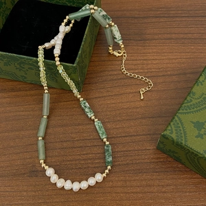 Detail of bamboo-style green agate beads and freshwater pearls on a vintage wood backdrop