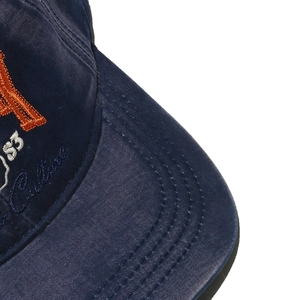 Macro shot of orange 3D embroidery on washed navy blue cotton vintage baseball cap