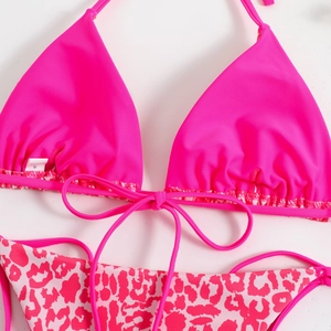 Close-up of bright pink triangle bikini top and leopard print bottoms with tie details