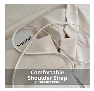 Detailed close-up of the smooth white cylindrical shoulder strap of the saddle bag