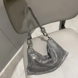 Close-up of sparkling silver rhinestone handbag featuring a knotted handle detail