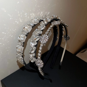 Dettaglio di tre cerchietti di lusso con strass e cristalli a forma di foglia