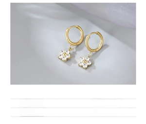 Detailed shot of gold-plated titanium hoop earrings with zircon-set flower charms