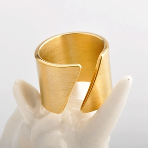 Minimalist gold stainless steel open ring with a matte brushed finish on a pedestal