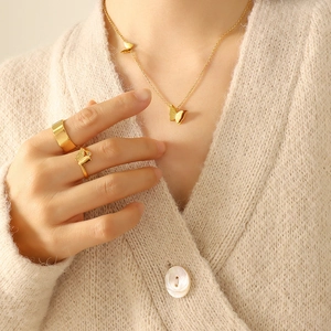 Elegant gold butterfly jewelry set with frosted pendant necklace and stylish rings on a model