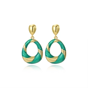 Detailed view of gold spiral earrings with green enamel oil drop finish on white background