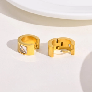Detailed close-up of gold-plated chunky hoop earrings with square cubic zirconia setting
