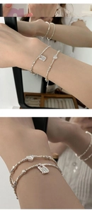 Detail of silver heart charm bracelet with engraved square tag You deserve to be loved